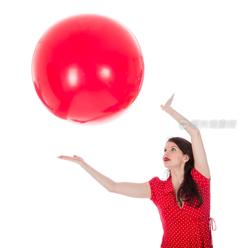 一个女人在她头上抓住一个红色的大气球