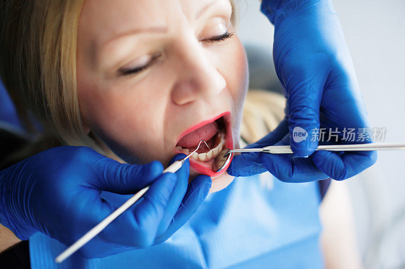 牙医为老年妇女检查和修复牙齿