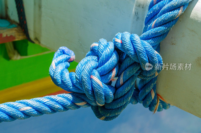 蓝绳牵着一条带结的彩船