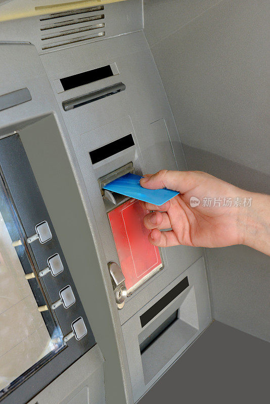 男性手插入信用卡在ATM机