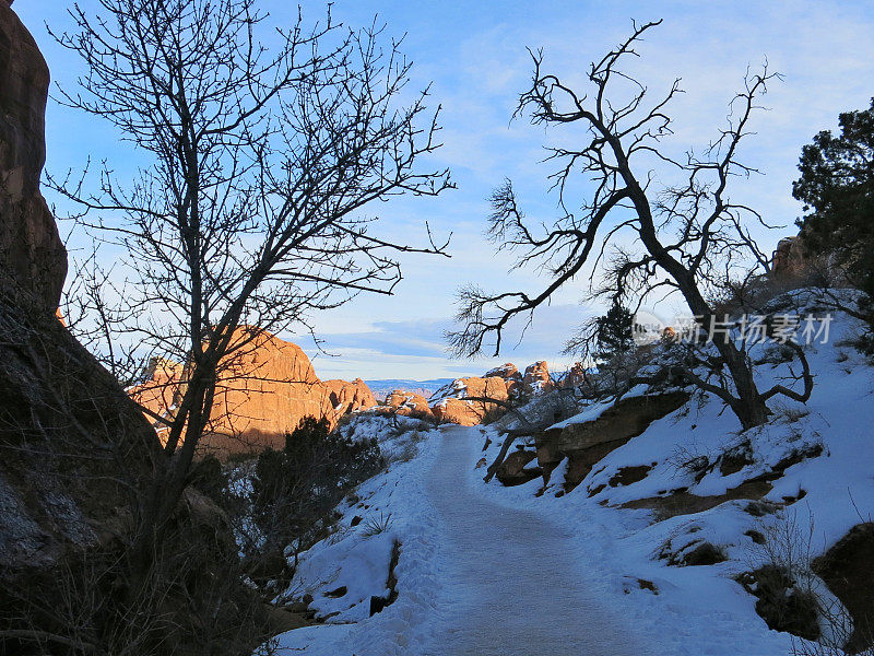 阴影覆盖的打包雪道，岩石形成，拱门，犹他州