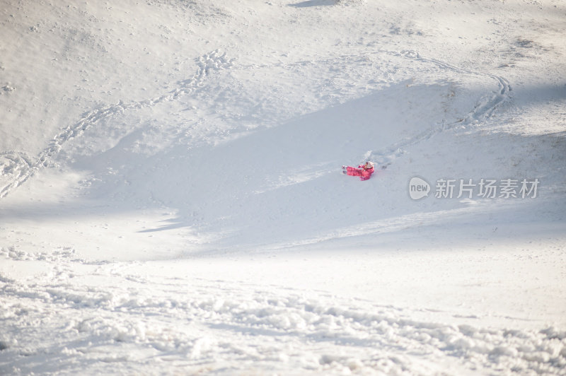 孩子在雪地上滑倒了