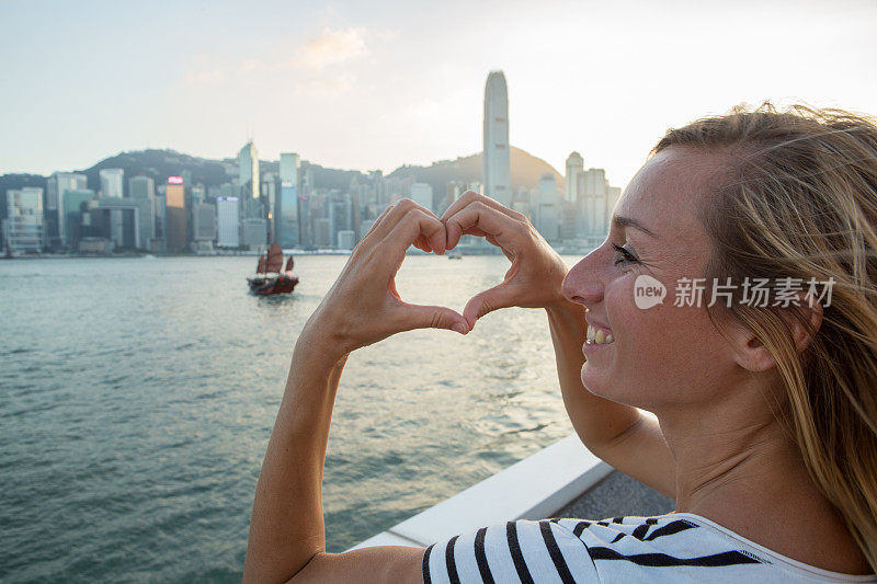 美丽的年轻女子做心形框架到香港