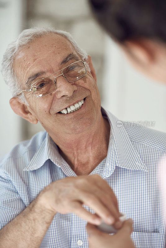 快乐的老年病人在家与护士交谈