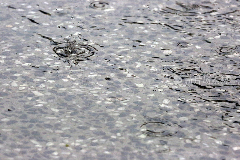 新加坡:雨滴在水坑里溅起水花
