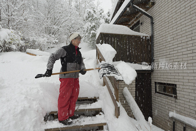 在冬天大雪中铲雪的妇女