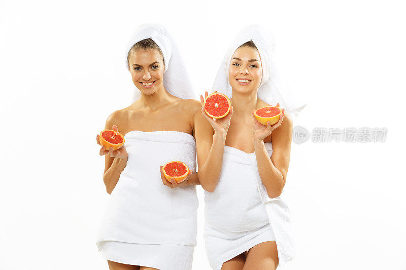 两个快乐的少女淋浴后玩柚子
