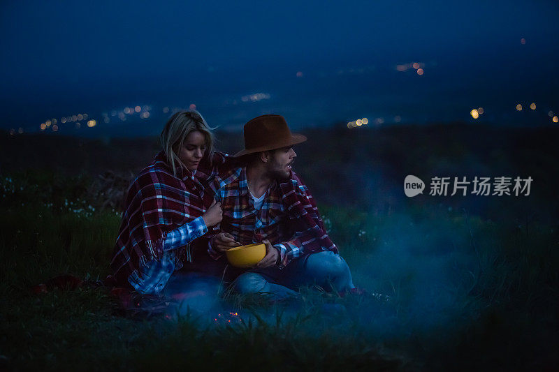 年轻夫妇在大自然中篝火晚会