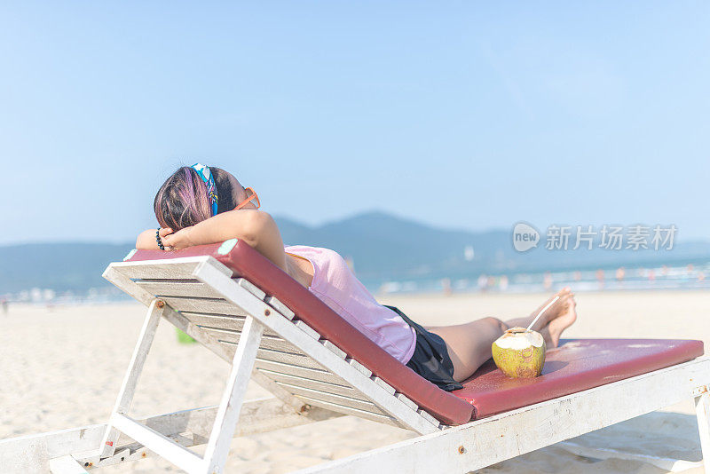 一个女人躺在沙滩上享受日光浴