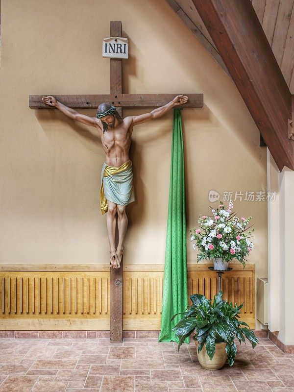 天主教堂十字架耶稣挂在十字架上，鲜花环绕