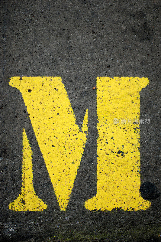 混凝土上的黄色字母M
