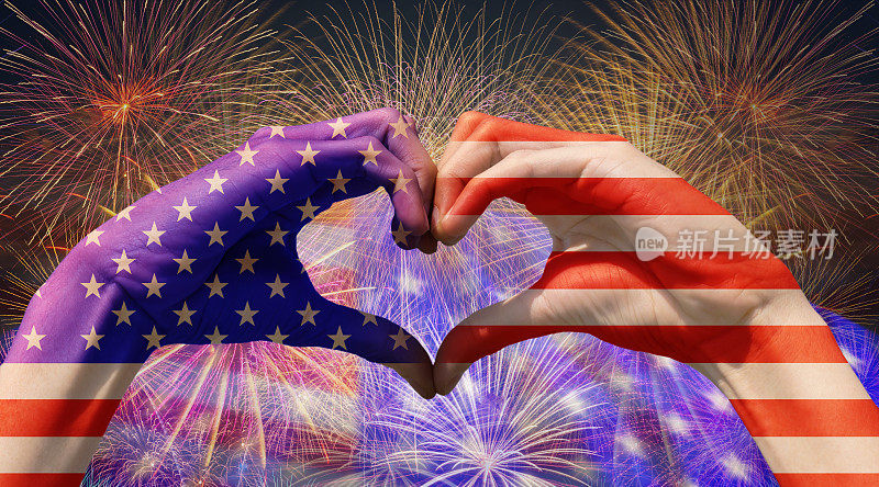 手形成的心与美国国旗上的多色烟花庆祝美国国旗的背景，独立日的概念