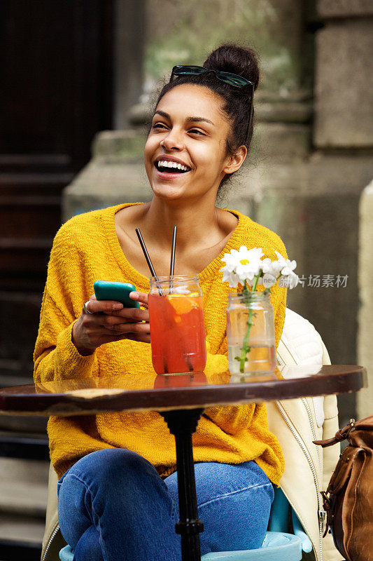 非裔美国妇女在户外咖啡馆看起来很开心