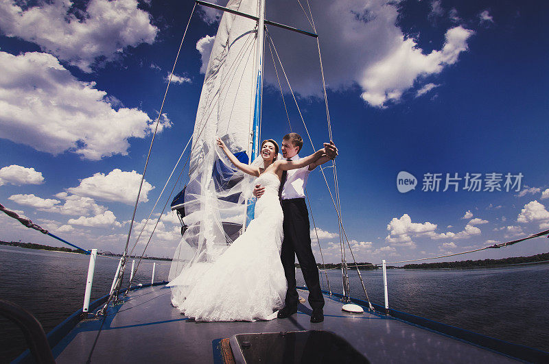 幸福的新娘和新郎在游艇上拥抱