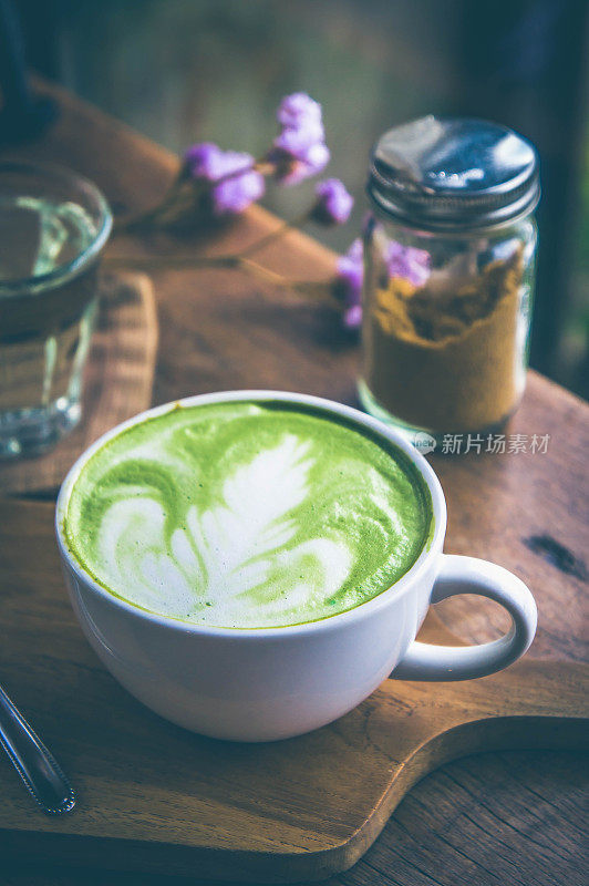 绿茶热饮拿铁白杯放在木桌上，香气馥郁，休闲时光在咖啡厅咖啡厅