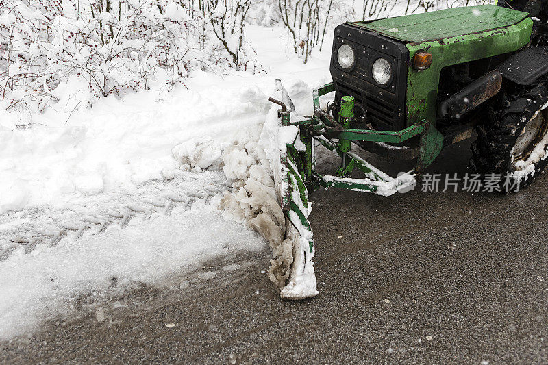 挖掘机清理城市街道上的积雪