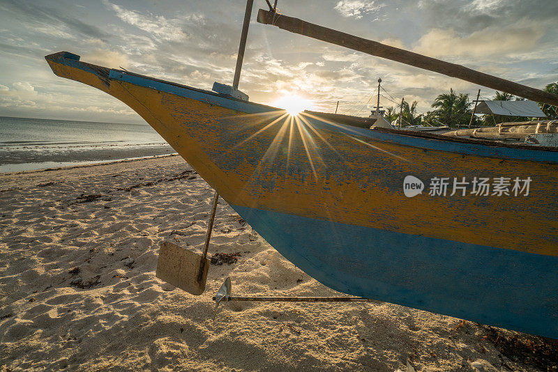 日落时分，菲律宾热带海滩上的渔船