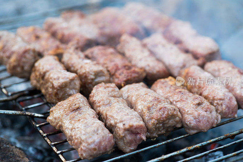 烤架上多汁美味的生肉末。烤肉串。