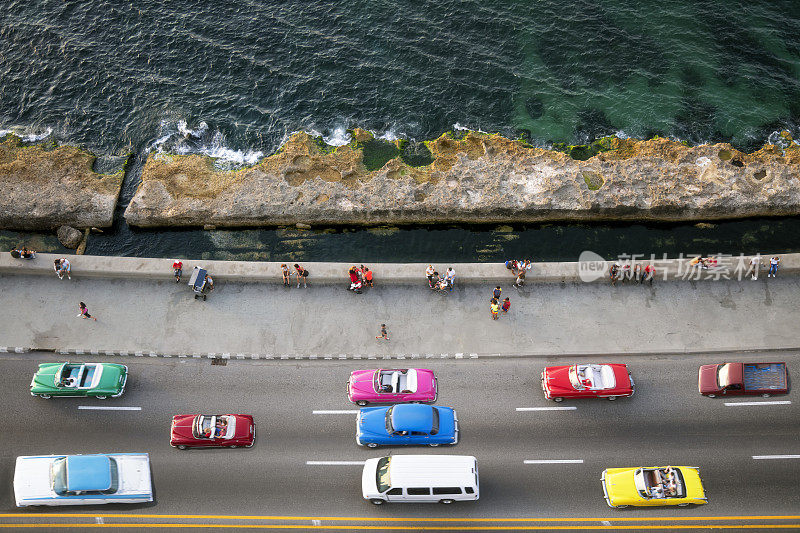 大群美国老爷车在哈瓦那马勒孔高速行驶，鸟瞰图