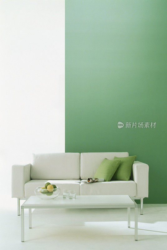 绿色墙壁的房间里有沙发和咖啡桌