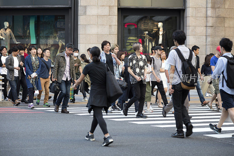 在日本东京，一群人穿过马路