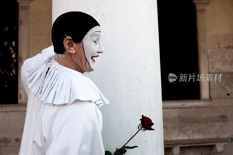 在威尼斯狂欢节期间，一名男子穿着传统的威尼斯皮埃罗服装在威尼斯街道上摆姿势