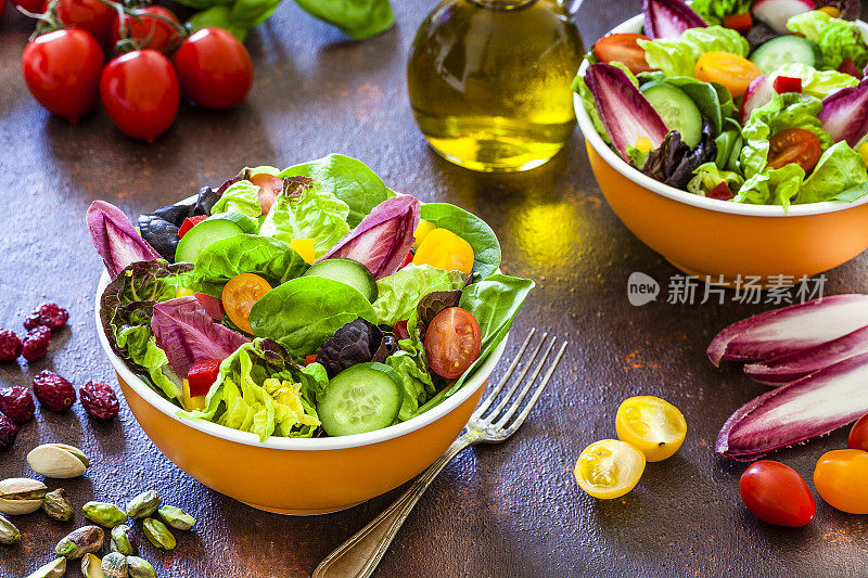 健康饮食:两个新鲜的沙拉碗准备在棕色的桌子上吃