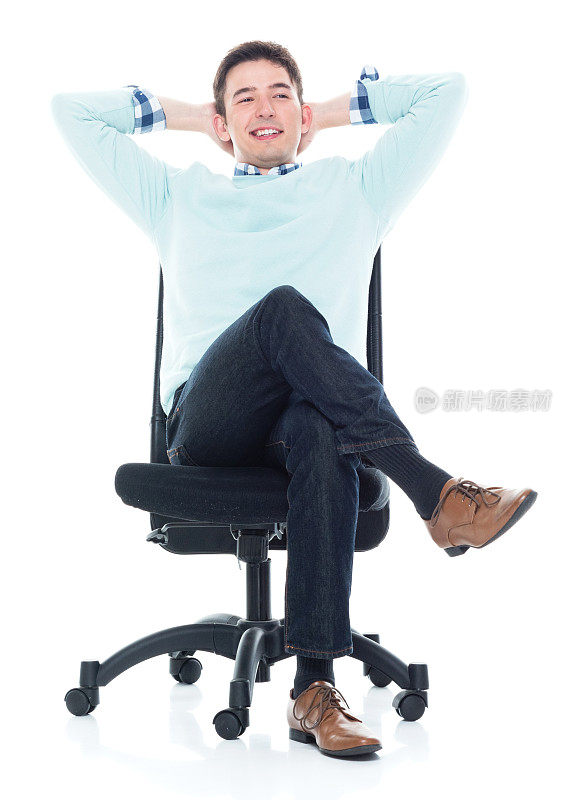 英俊的年轻人坐在椅背上，手放在脑后