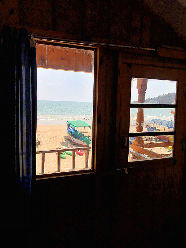 Palolem海滩小屋和从抬高的高木制树屋海滩小屋窗户俯瞰阳台阳台的照片，印度南部果阿海滩，果阿度假房间有树屋窗户，阳台阳台俯瞰海边和大海
