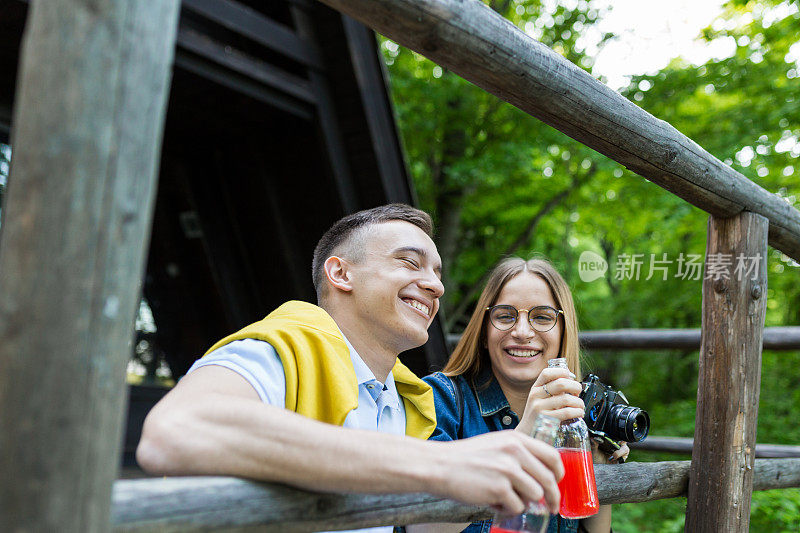 一对年轻夫妇在森林里享受着他们的爱情，面带微笑