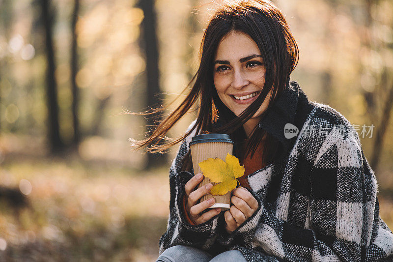 快乐的女人在森林里享受美丽的秋日