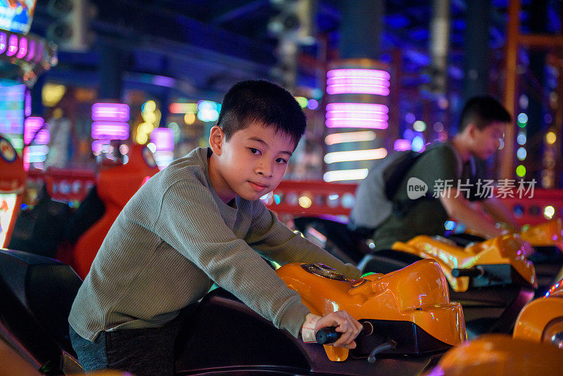 年轻的亚洲男孩玩电玩机