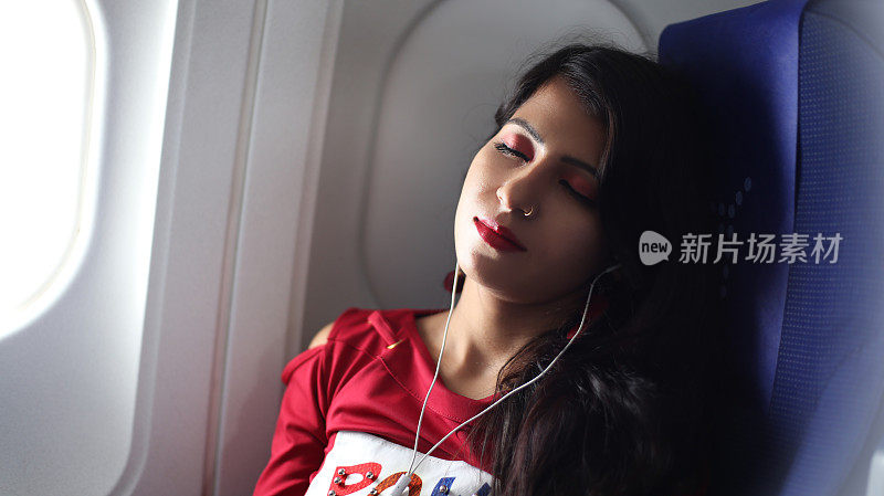放松的女人坐飞机旅行，听音乐