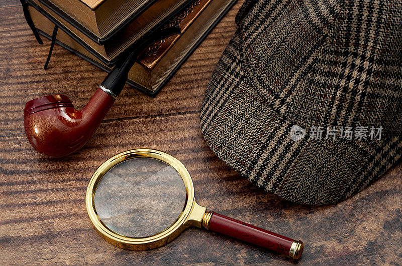 文学小说，警察探长，调查犯罪和神秘故事的概念与福尔摩斯侦探帽，抽烟斗，复古放大镜和书孤立在木头桌上