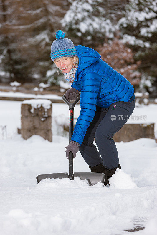 老妇人拿着雪铲