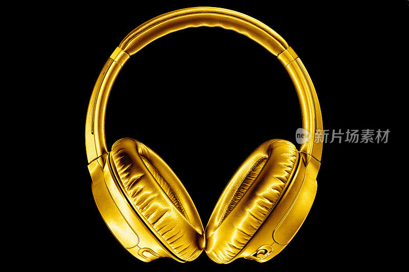 金色闪亮的无线耳机黑色背景隔离特写，昂贵的金色金属蓝牙耳机，现代高端wi-fi黄色耳机，音频音乐符号，立体声音响电子标志
