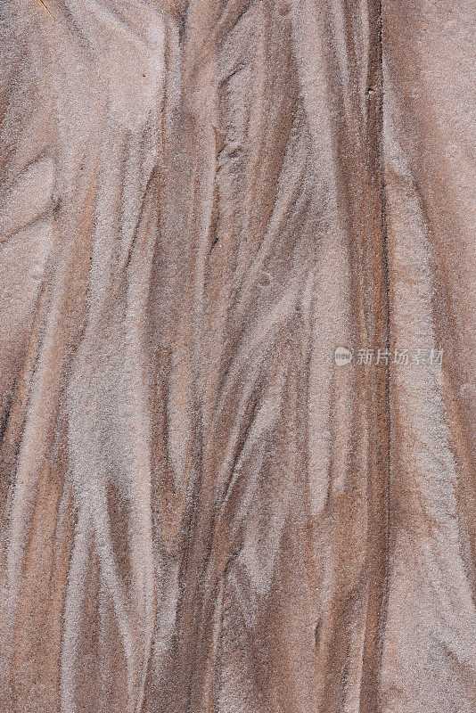 被侵蚀的沙子呈米色、棕色和白色