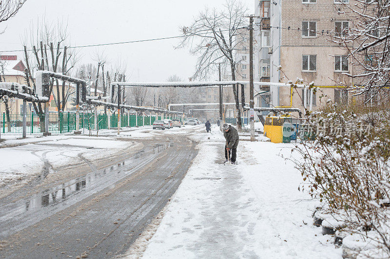 人们用铲子清理人行道上的积雪。