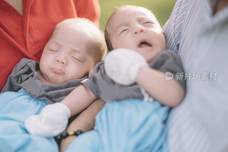 2个亚洲双胞胎男婴被祖父母抱着
