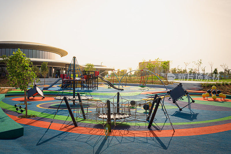 在沙迦的公共公园玩建筑，有橡胶土墩，滑梯，攀爬选择，旋转网秋千等。