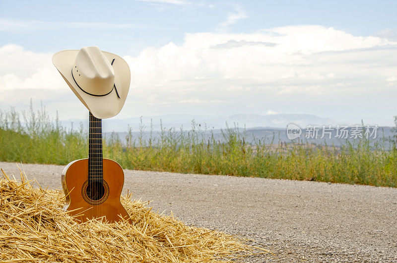 吉他，牛仔帽，干草和土路