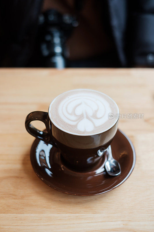 一杯热艺术巧克力咖啡在咖啡馆的木桌上