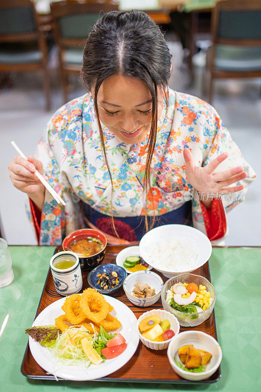 穿着和服的日本妇女惊讶地看着食物