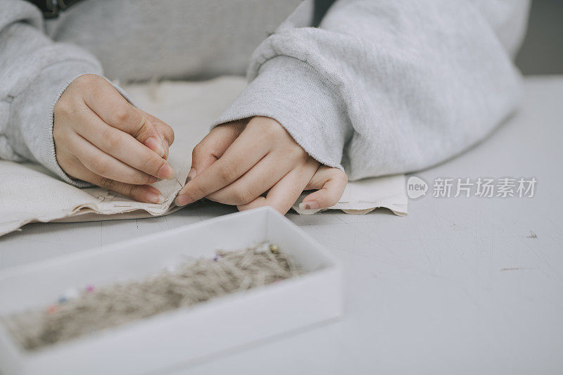 亚洲华裔女大学生在大学工作坊做服装项目