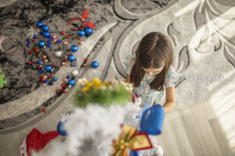 一个小女孩喜欢装饰圣诞树