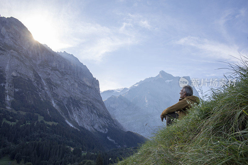 日出时分，徒步旅行者在高山草地上放松