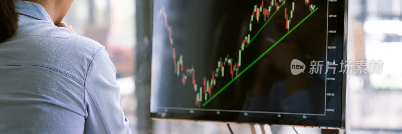 股票市场经纪人穿正装分析图表在办公室屏幕上，投资概念