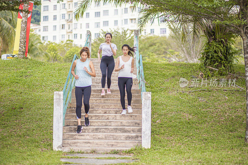 一群亚洲华人妇女在公园里跑步。