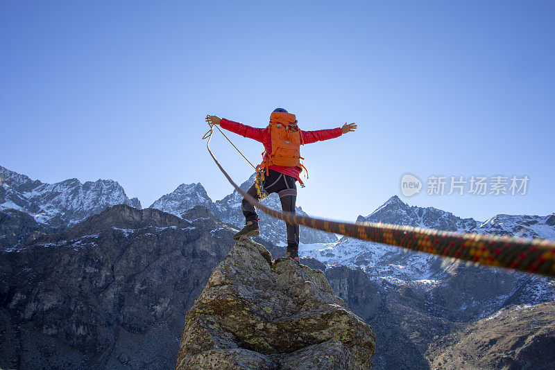 一个登山家登上了顶峰，伸开双臂