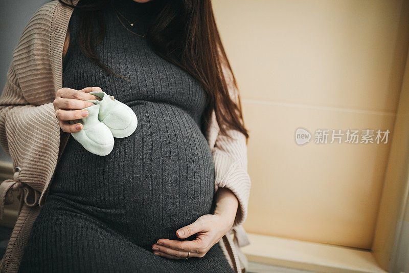 抱着小鞋子的孕妇